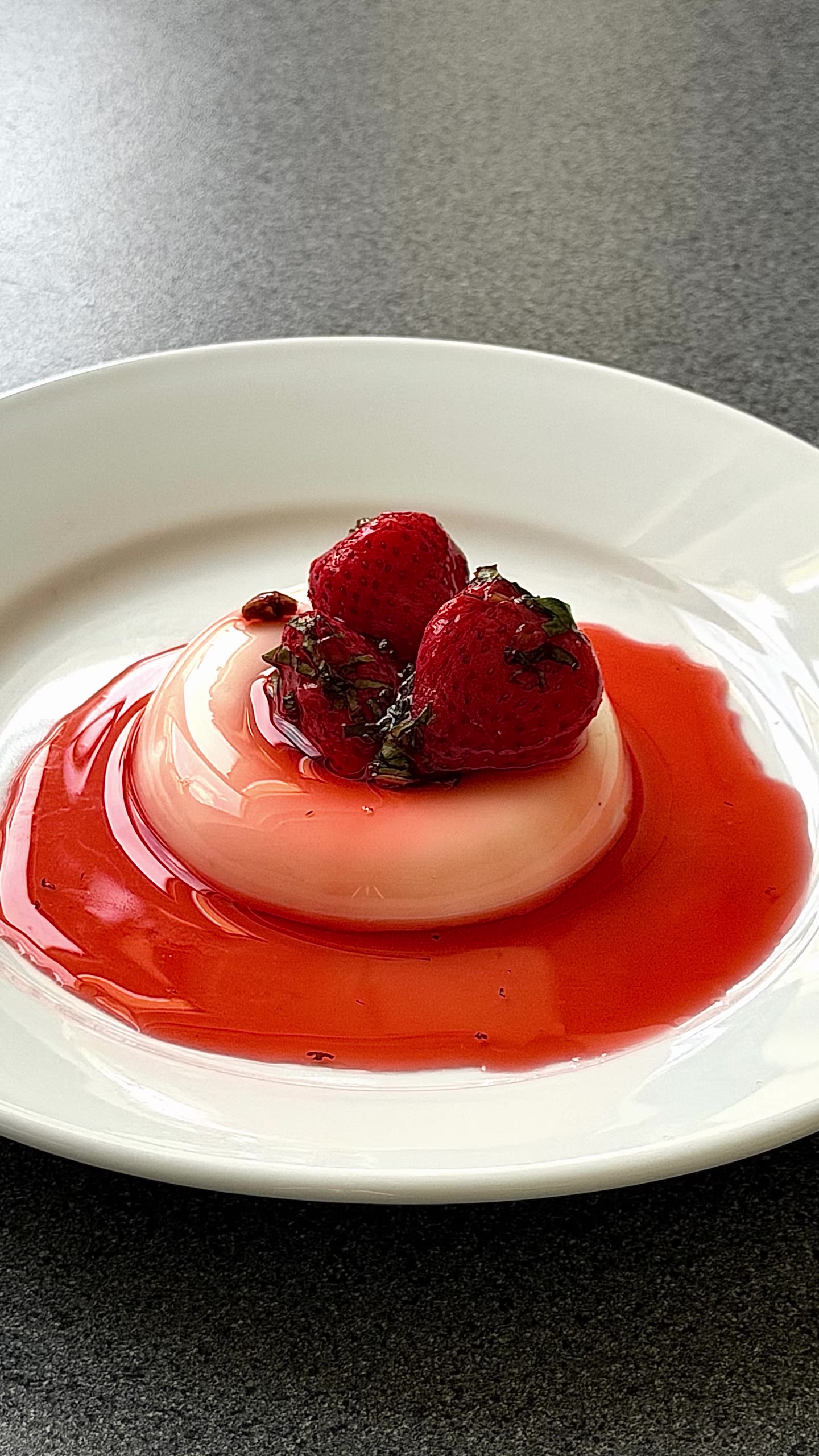 A berry-topped dessert with red fruit sauce