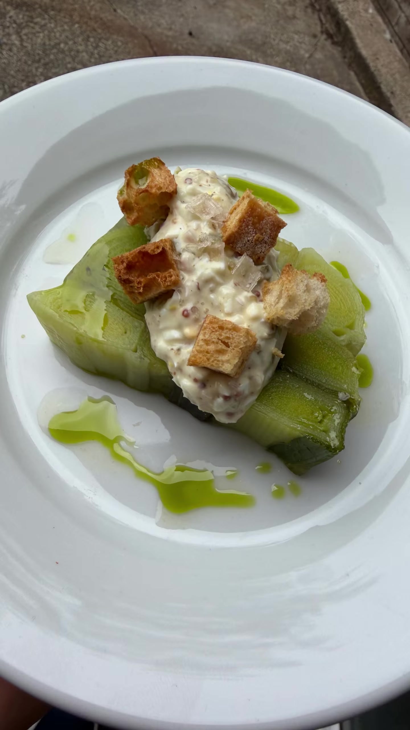 Seasonal vegetables with a creamy topping, croutons and green oil